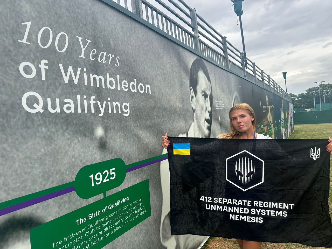 Oleksandra Oliynykova holding the NEMESIS flag at Wimbledon